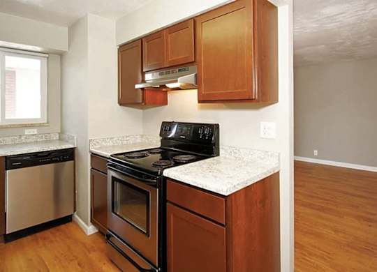 A kitchen with wooden cabinets and a black stove top oven.