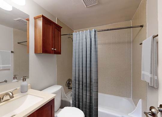 A bathroom with a white tub and a white toilet.