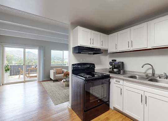 A kitchen with white cabinets and a black stove top oven.