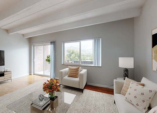 A living room with a white couch, a coffee table, and a flat screen TV.