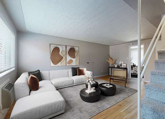 A living room with a white couch and a blue carpeted staircase.