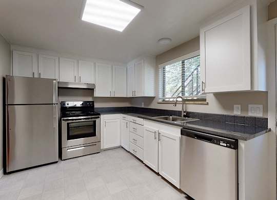 A modern kitchen with stainless steel appliances and white cabinets.