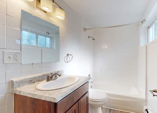 A bathroom with a white tub and a white sink.
