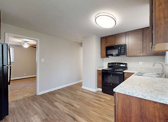 A kitchen with a black oven and microwave built into the cabinetry.