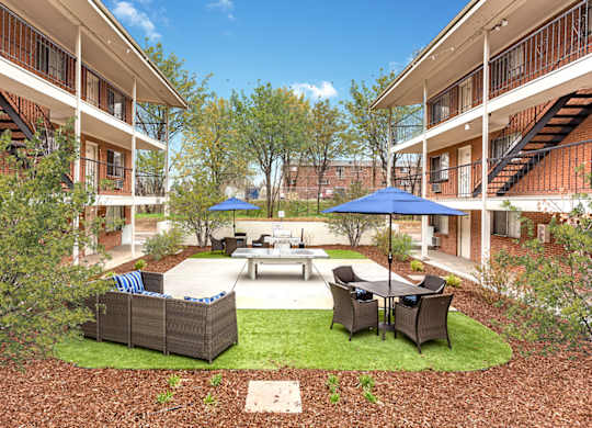 A courtyard with a table and chairs surrounded by buildings.