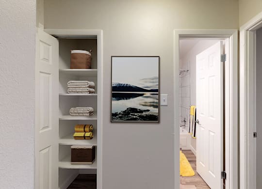 A bathroom with a white door and a picture of a beach on the wall.
