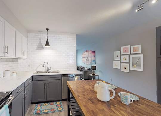 A kitchen with a stove top oven and a wooden counter top.