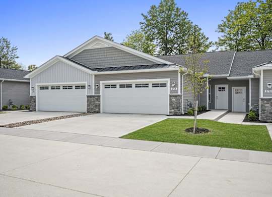 A house with a grey roof and white garage doors.