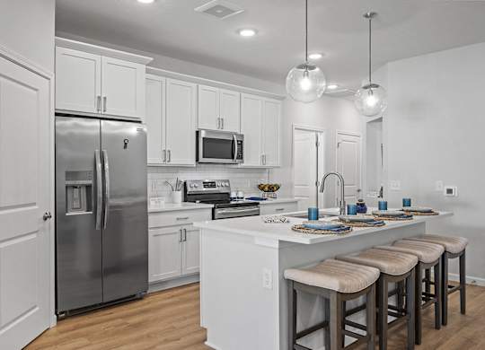 A modern kitchen with white cabinets and a central island.