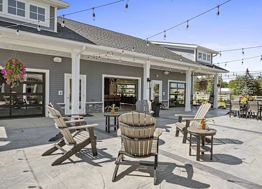 A patio with chairs and a table is set up outside a house.