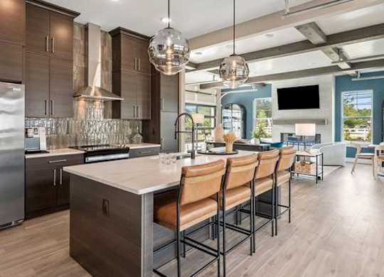 A modern kitchen with a center island and stainless steel appliances.