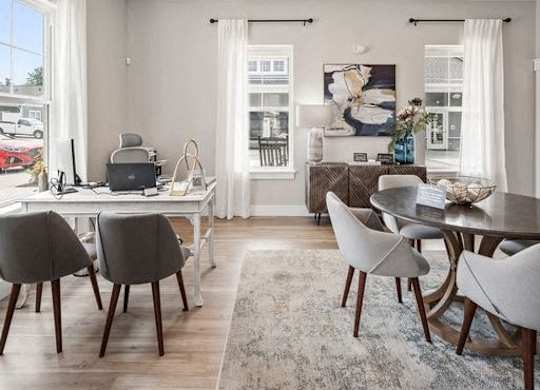 A modern dining room with a laptop on the table and a view of the street outside.