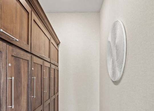 A long hallway with wooden doors and a white ceiling fan.
