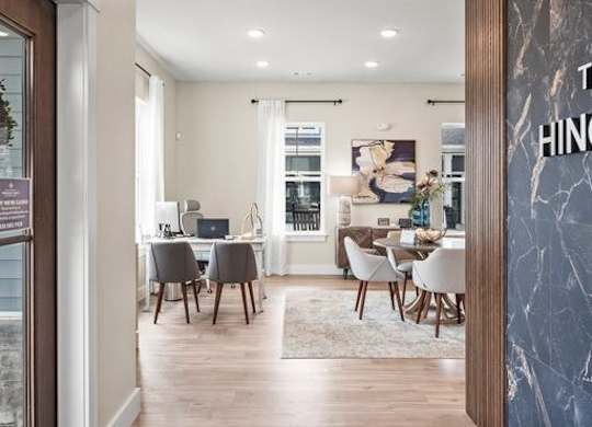 A modern dining room with a marble wall and a wooden floor.
