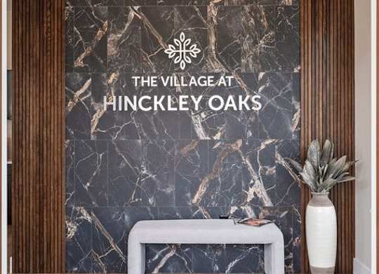 A modern lobby with a marble wall and a white bench.