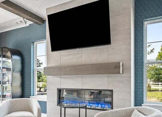 A modern living room with a flat screen TV mounted above a fireplace.
