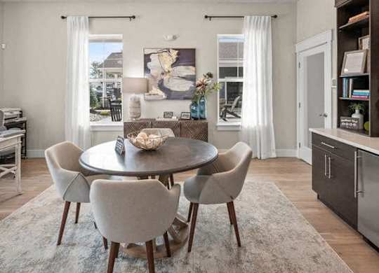 A modern dining room with a round table and chairs.