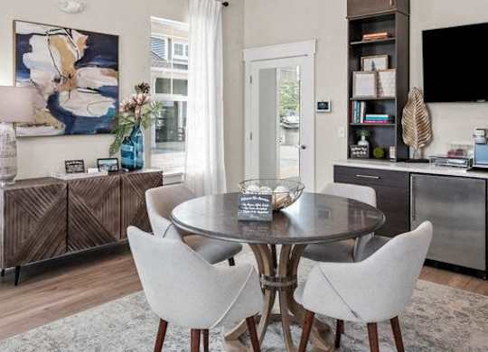 A modern dining room with a glass table and chairs.