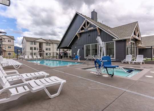 A pool area with a blue chair and a white chair at Marcola Apartment Homes, Forest Grove, Oregon