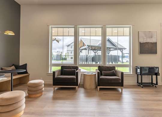 A living room with two chairs and a table at Marcola Apartment Homes, Forest Grove