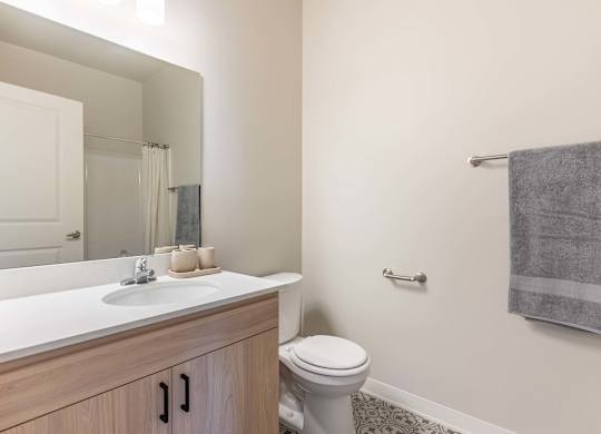 A bathroom with a toilet, sink, and mirror at Marcola Apartment Homes, Forest Grove, OR, 97477