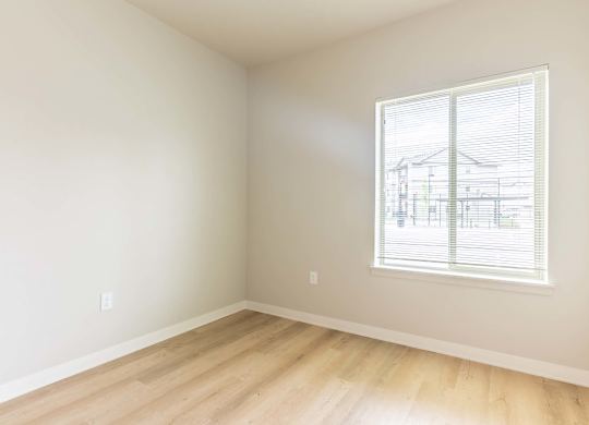 A room with a window showing a view of a house at Marcola Apartment Homes, Oregon, 97477