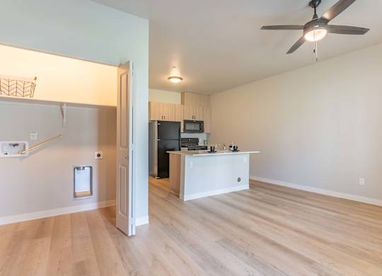 A room with a ceiling fan and a kitchen area with a microwave and oven at Marcola Apartment Homes, Oregon
