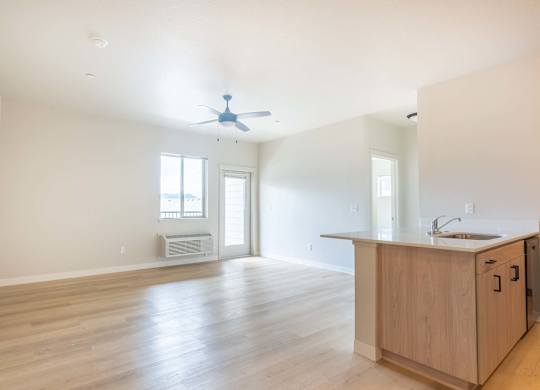 A kitchen area with a sink, a window, and a fan at Marcola Apartment Homes, Forest Grove, OR, 97477