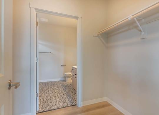 A white door opens to a bathroom with a toilet and a sink at Marcola Apartment Homes, Oregon