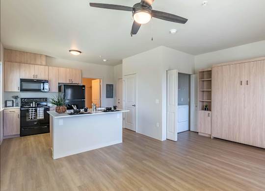 A kitchen with a white island and wooden floors at Westgate Apartment Homes, Oregon, 97801