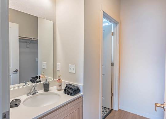A bathroom with a sink, mirror, and towel at Westgate Apartment Homes, Pendleton, Oregon