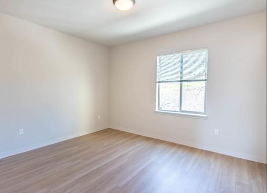 A room with a window and wooden flooring at Westgate Apartment Homes, Pendleton