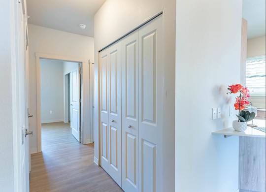 A hallway with white doors and a mirror on the wall at Westgate Apartment Homes, Pendleton