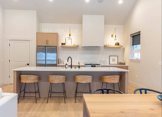 A kitchen with a white counter top and bar stools at Westgate Apartment Homes, Pendleton, OR, 97801