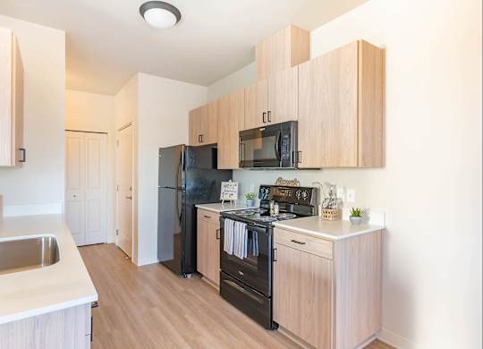 A kitchen with wooden cabinets and black appliances at Westgate Apartment Homes, Pendleton, 97801