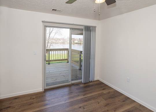 A room with a sliding glass door leading to a deck.