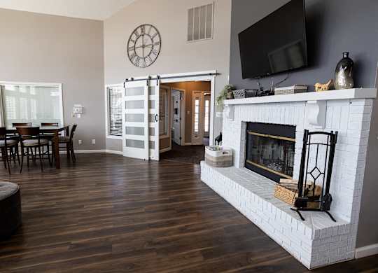 A living room with a fireplace and a television mounted on the wall.