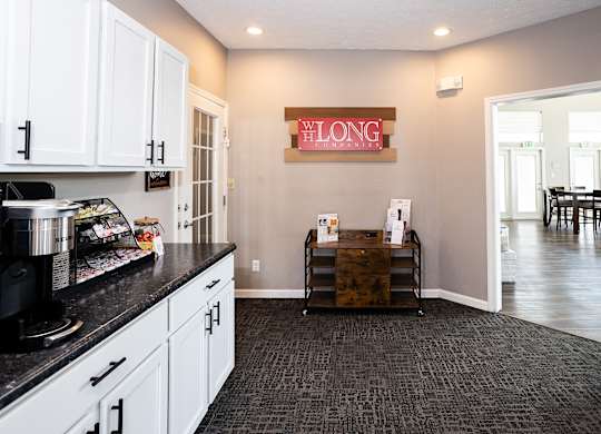 A kitchen with a black counter top and white cabinets.