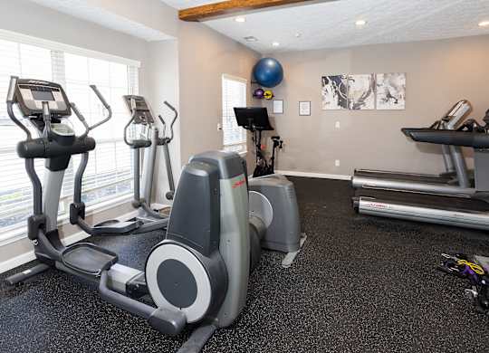 A gym with treadmills, elliptical machines, and other exercise equipment.