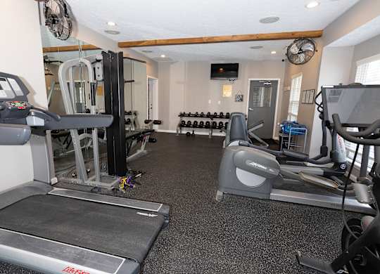 A gym with treadmills, weights, and exercise equipment.
