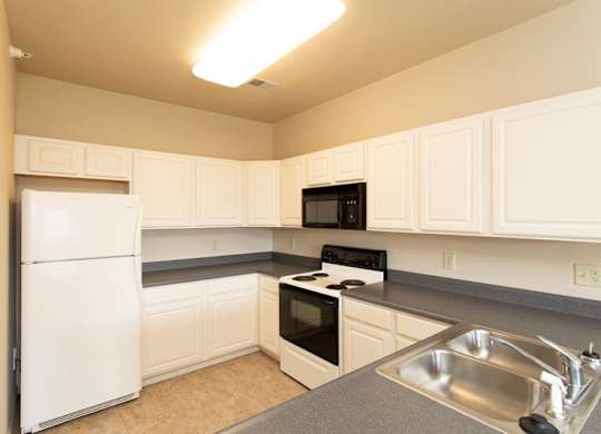 A kitchen with white appliances and cabinets.