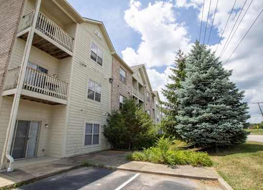 A large apartment complex with a tree in front.