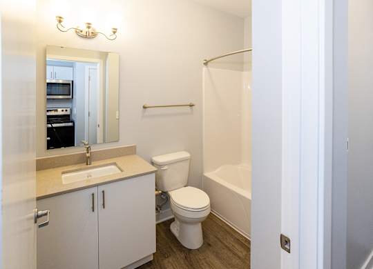 A white bathroom with a toilet, sink, and bathtub.