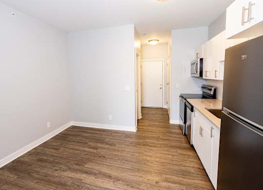 A kitchen with a refrigerator, microwave, and oven.