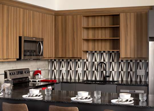 A modern kitchen with a bar area featuring two stools.at Damask, Ontario