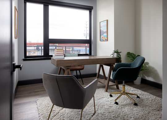 Large den featuring work desk and two chairs for home office at Damask, Windsor, ON