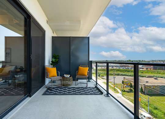 A balcony with a chair and a table with a plant on it at Damask, Ontario, N8S 0B7