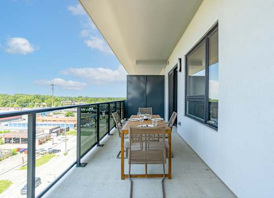 A balcony with a table and chairs overlooking a street at Damask, Ontario
