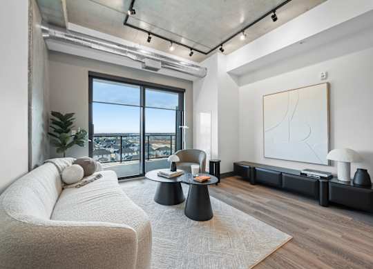 A modern living room with a large window overlooking the city at Damask, Windsor, ON N8S 0B7