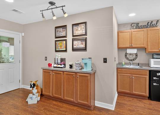 A kitchen with a brown dog sitting in front of a counter at Sawbranch Apartments, Summerville, SC
